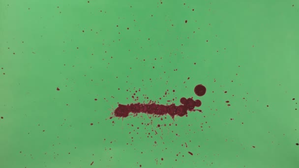 Rött bläck Splatter över grön skärmbakgrund — Stockvideo