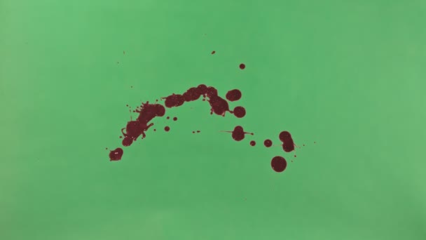 Éclaboussure d'encre rouge sur fond d'écran vert 