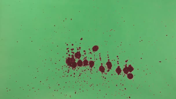 Красные чернила брызги на зеленом фоне экрана — стоковое видео
