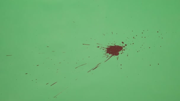 Éclaboussure d'encre rouge sur fond d'écran vert 