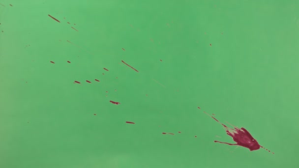 Éclaboussure d'encre rouge sur fond d'écran vert 