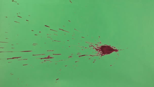 Éclaboussure d'encre rouge sur fond d'écran vert 