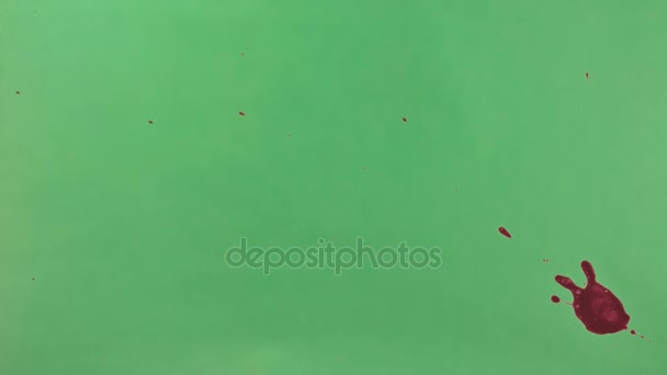 Éclaboussure d'encre rouge sur fond d'écran vert 