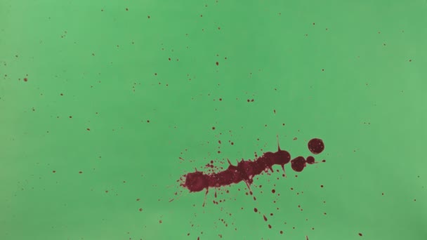 Salpicadura de tinta roja sobre fondo de pantalla verde — Vídeo de stock