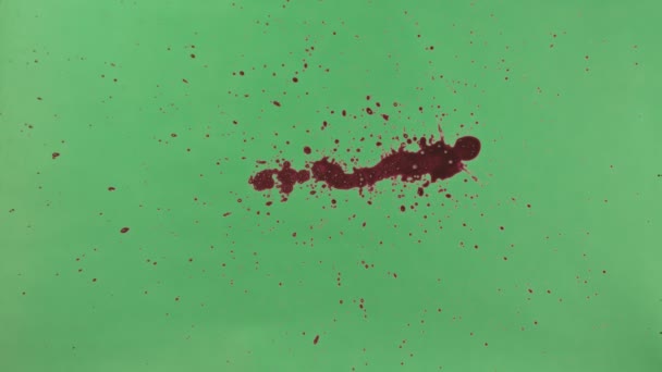 Éclaboussure d'encre rouge sur fond d'écran vert 