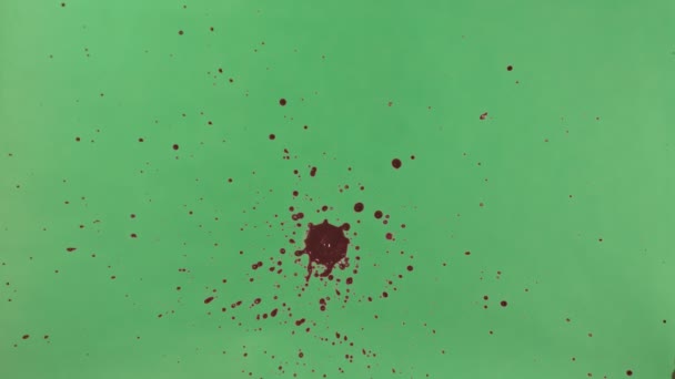 Éclaboussure d'encre rouge sur fond d'écran vert 