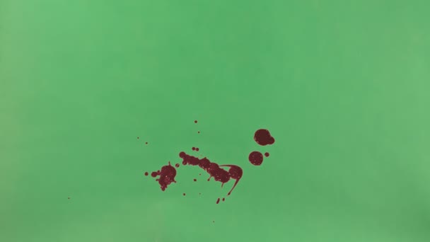 Éclaboussure d'encre rouge sur fond d'écran vert 