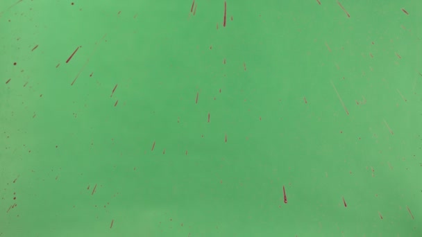 Encre rouge saupoudré sur fond d'écran vert 