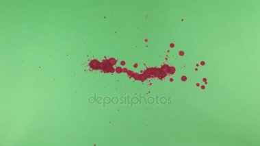 Kırmızı mürekkep sıçramak yeşil ekran arka planı üzerinde