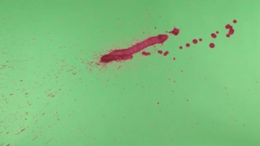 Kırmızı mürekkep sıçramak yeşil ekran arka planı üzerinde