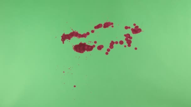 Salpicadura de tinta roja sobre fondo de pantalla verde — Vídeo de stock