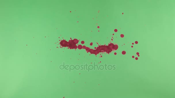 Éclaboussure d'encre rouge sur fond d'écran vert 