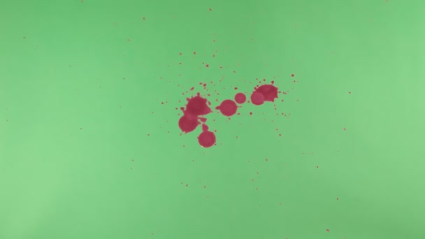 Éclaboussure d'encre rouge sur fond d'écran vert 