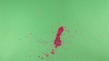 Kırmızı mürekkep sıçramak yeşil ekran arka planı üzerinde