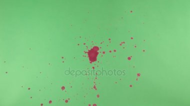 Kırmızı mürekkep sıçramak yeşil ekran arka planı üzerinde