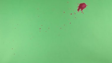 Kırmızı mürekkep sıçramak yeşil ekran arka planı üzerinde