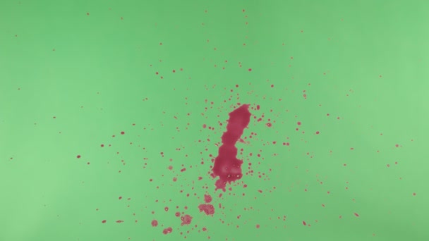 Éclaboussure d'encre rouge sur fond d'écran vert 