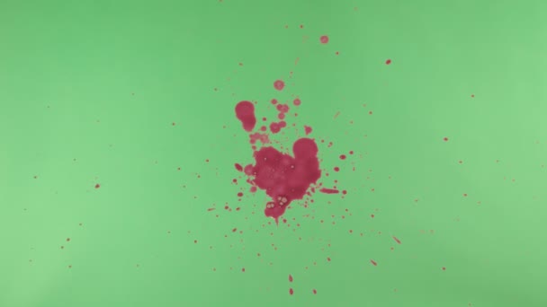 Éclaboussure d'encre rouge sur fond d'écran vert 
