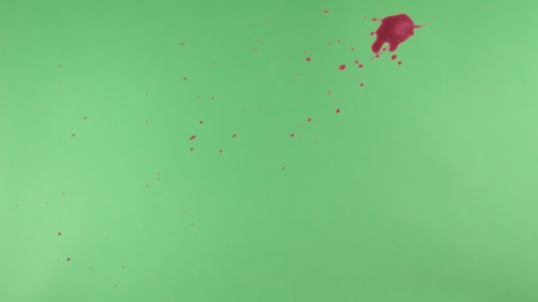 Éclaboussure d'encre rouge sur fond d'écran vert 