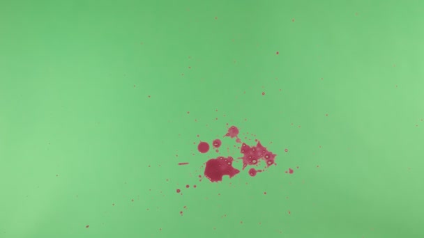 Éclaboussure d'encre rouge sur fond d'écran vert 