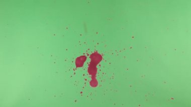 Kırmızı mürekkep sıçramak yeşil ekran arka planı üzerinde