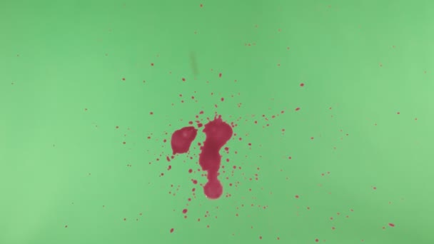 Éclaboussure d'encre rouge sur fond d'écran vert 