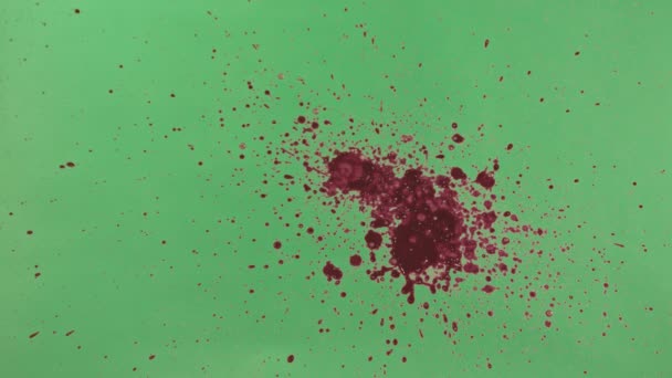 Éclaboussure d'encre rouge sur fond d'écran vert 