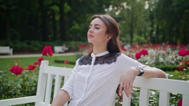 Parkta beyaz bankta oturan öpebileceğinize Bayan