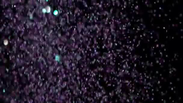 Paillettes réalistes explosant sur fond noir .