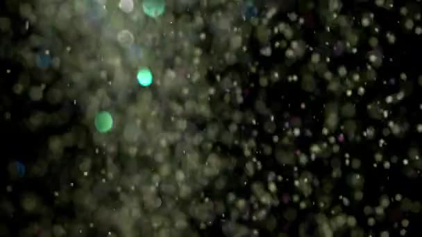 Paillettes réalistes explosant sur fond noir .