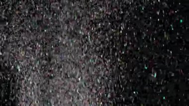 Siyah arka plan üzerinde patlayan gerçekçi Glitter.