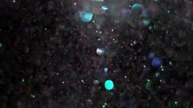 Siyah arka plan üzerinde patlayan gerçekçi Glitter.