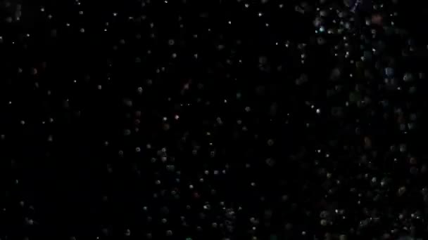 Paillettes réalistes explosant sur fond noir .