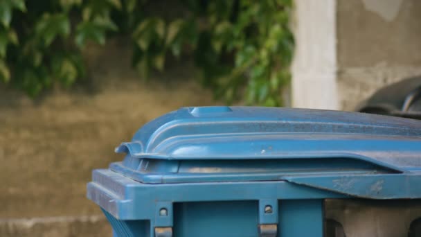 Junger Mann in roter Sportbekleidung wirft Müll weg — Stockvideo