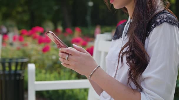 Damen i parken med hjälp av en telefon — Stockvideo