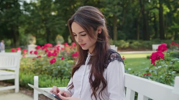 Dama en el parque usando una tableta — Vídeos de Stock