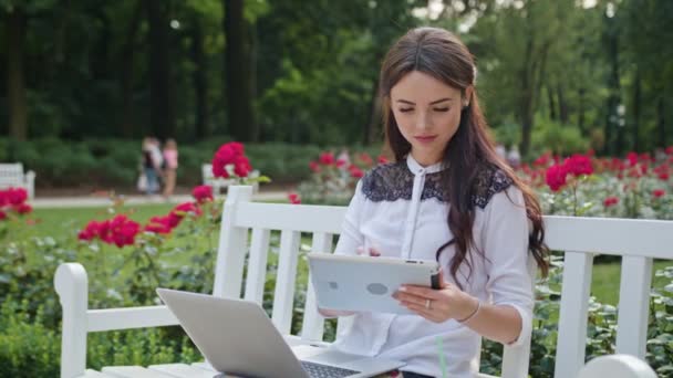 Lady στο πάρκο χρησιμοποιώντας φορητό υπολογιστή και Tablet — Αρχείο Βίντεο