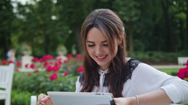 Dama en el parque usando una tableta — Vídeos de Stock