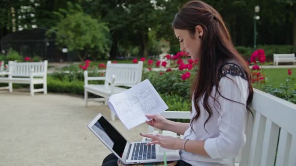 Dame assise dans le parc, utilisant un ordinateur portable. Saisie des données — Video