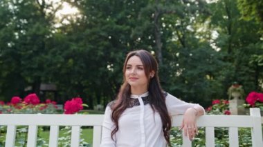 Parkta beyaz bankta oturan öpebileceğinize Bayan