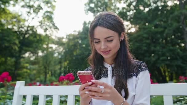 Senhora no parque usando um telefone — Vídeo de Stock