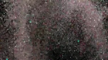 Siyah arka plan üzerinde patlayan gerçekçi Glitter.