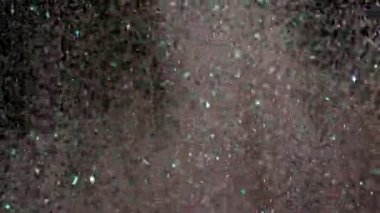 Siyah arka plan üzerinde patlayan gerçekçi Glitter.