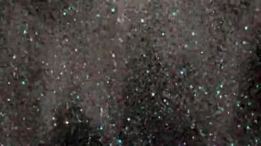 Siyah arka plan üzerinde patlayan gerçekçi Glitter.