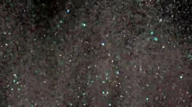 Siyah arka plan üzerinde patlayan gerçekçi Glitter.