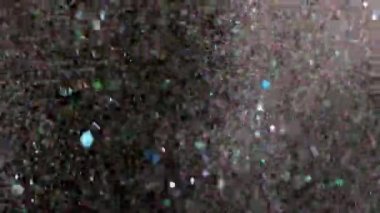 Siyah arka plan üzerinde patlayan gerçekçi Glitter.