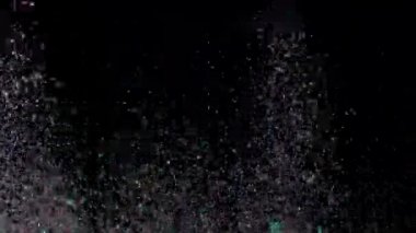 Siyah arka plan üzerinde patlayan gerçekçi Glitter.