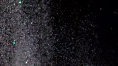 Siyah arka plan üzerinde patlayan gerçekçi Glitter.