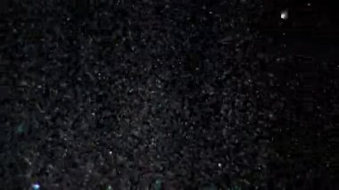 Siyah arka plan üzerinde patlayan gerçekçi Glitter.