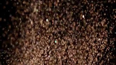 Siyah arka plan üzerinde patlayan gerçekçi Glitter.